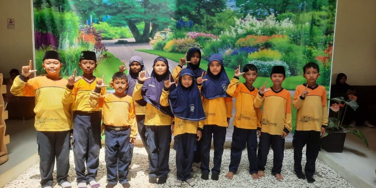 Duta Literasi MIM Kauman berfoto bersama dalam kunjungan perpustakaan